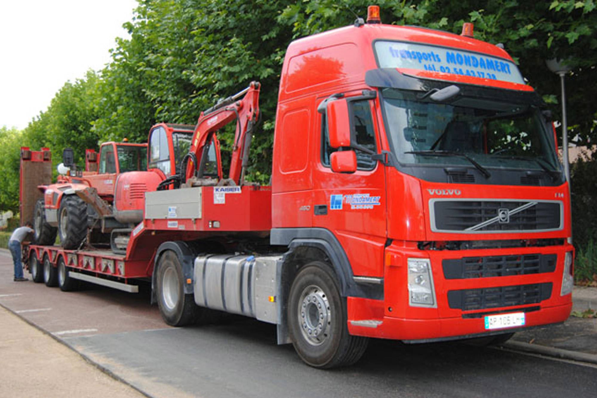 Camion porte-engin transportant matériels BTP